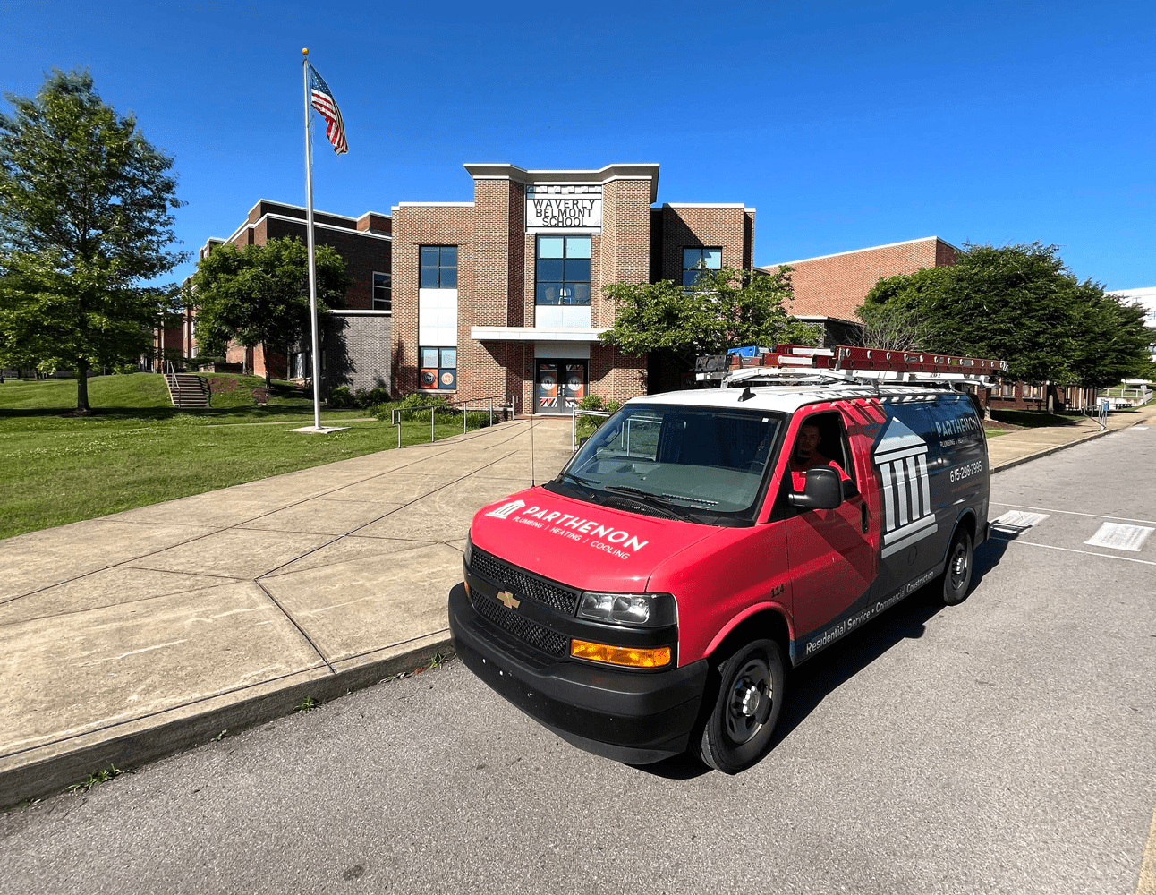 Service van parked outside a school building.