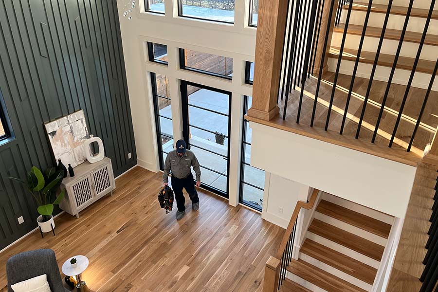 Technician entering modern home with tool bag in hand