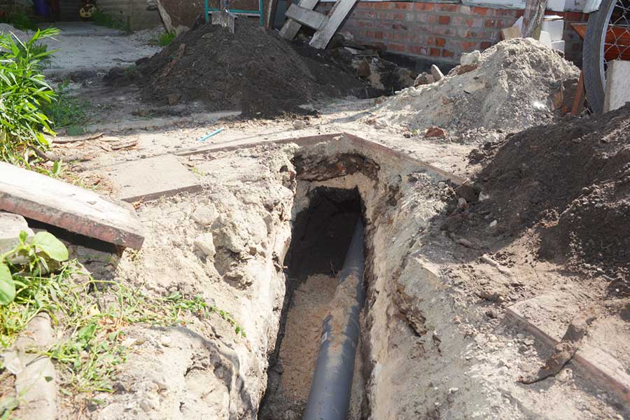 Trench with new sewer line pipe installation in progress