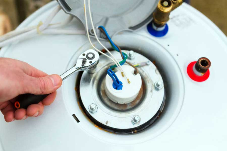 Person using a wrench to adjust a water heater component
