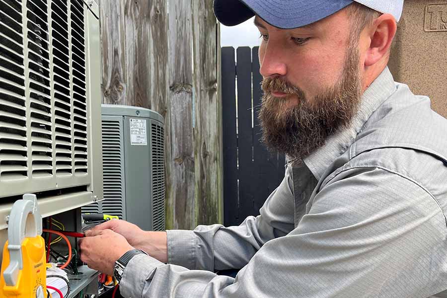 Technician inspecting electrical components during HVAC maintenance service