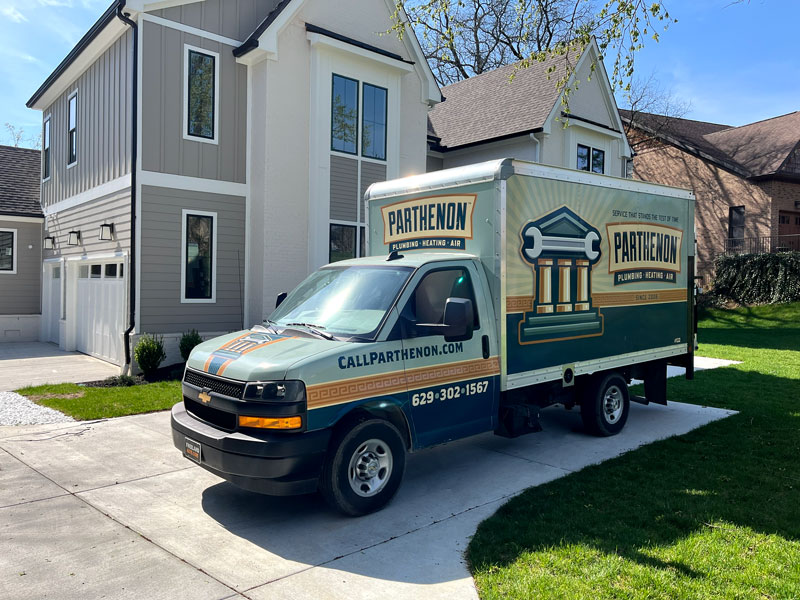 Parthenon HVAC maintenance truck parked in a driveway beside a modern home