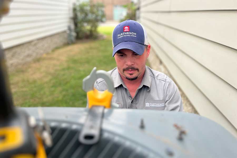 Technician checking a residential HVAC system during a repair service